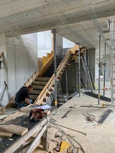 a man is working on some stairs in a building that's under construction with scaffolding