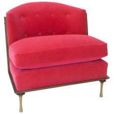 a pink chair with wooden legs and a buttoned up armrest on an isolated white background