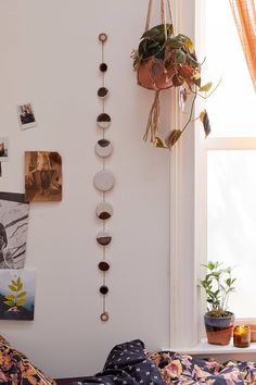 a room with a bed, plants and pictures on the wall