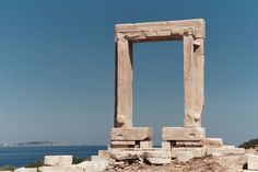 an old stone structure sitting next to the ocean