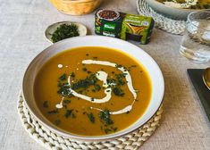 a white bowl filled with soup on top of a table next to other bowls and spoons