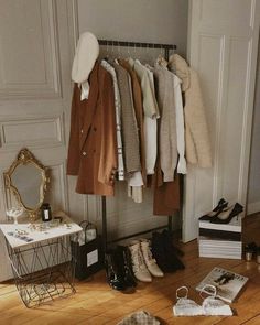 clothes and shoes are hanging on a rack in a room