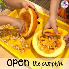 two children are cutting pumpkins on a yellow tray with the words open the pumpkin