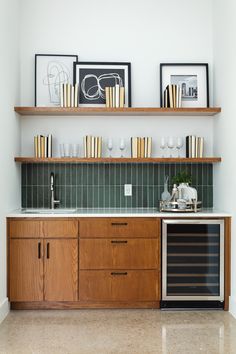 a kitchen with wooden cabinets and shelves filled with wine glasses