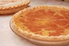 two pies sitting on top of a table next to each other, one is yellow