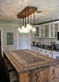 a kitchen with an island made out of wooden planks and lights hanging from the ceiling