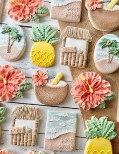 some decorated cookies sitting on top of a wooden table with flowers and palm trees in the background