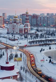 the city is covered in snow and lit up at night