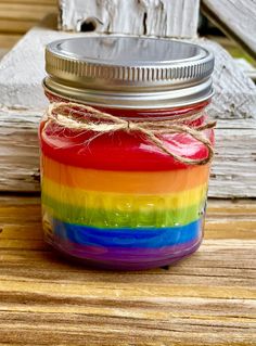 a rainbow colored jar sitting on top of a wooden table