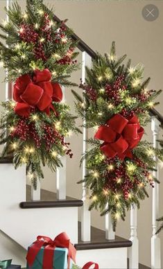 christmas decorations on the banisters and stairs with red bows, pine cones and lights