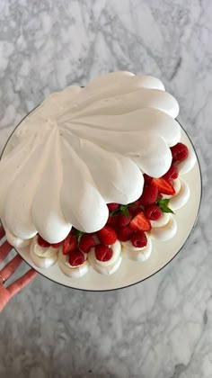 a cake with white frosting and strawberries on top