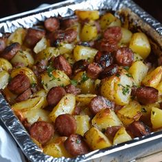 a metal pan filled with potatoes and sausage