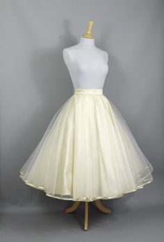 "This show stopping bridal skirt is made from a layer of Champagne Silk Dupion and a layer of ivory tulle hemmed in Gold trim. The tulle layer is a double circle which means lots and lots of volume! Wear with a 'Swing' petticoat for extra swish on the dance floor (or seen in the last photo without a petticoat underneath) and choose your length to create a unique outfit for your special day. This over-skirt can be made in a range of standard sizes or can be made to fit your exact waist measuremen Gold Champagne Bridesmaid Skirt, Double Citcle Skirt, Champagne Wedding Skirt, Wedding Tea Length Dress With Tulle Skirt, Organza Wedding Dress With Full Skirt, Fitted Organza Skirt For Wedding, Organza Full Skirt Wedding Dress, Wedding Petticoat With Voluminous Skirt, Fitted Full Tulle Petticoat