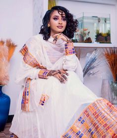 This radiant Habesha Kemis is a true masterpiece of Ethiopian fashion. The dress features a stunning Tilf design that is intricately woven into the fabric, creating a beautiful and unique pattern that catches the eye. The Tilf design is complemented by the Tilet bottom of the dress, which adds a touch of elegance and sophistication to the overall look. The Habesha Kemis is made from high-quality fabric that is soft to the touch and drapes beautifully on the body. The dress is designed to flatter Traditional Ceremony Dress With Sheer Dupatta, Floor-length Dresses For Traditional Ceremonies With Sheer Dupatta, Floor-length Dresses With Sheer Dupatta For Traditional Ceremonies, White Dabka Dress For Festive Occasions, Sheer Dupatta Dress For Navratri Ceremonies, Chanderi Handloom Wedding Dress, Wedding Chanderi Handloom Dresses, Handloom Chanderi Wedding Dress, Fitted Chanderi Dress For Traditional Ceremonies