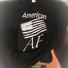 an american af t - shirt with the american flag on it is sitting next to a remote control