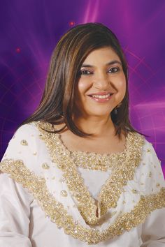 a woman wearing a white and gold outfit smiling at the camera, with purple background