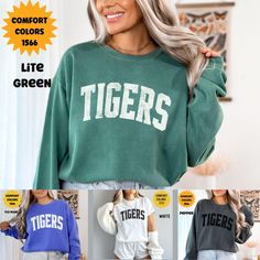 "Unleash the Spirit with Our Custom Tigers Mascot Comfort Colors Sweatshirt." This sweatshirt brings school pride and team spirit to a whole new level. With our custom mascot design, you can proudly represent your school or organization wherever you go. Made with the finest Comfort Colors fabric, it offers unparalleled comfort and durability. Whether you're cheering from the stands, on the field, or simply hanging out with friends, this sweatshirt is your ultimate go-to for coziness and style. S Relaxed Fit Lettering Tops For Campus, Green Crew Neck Top For Campus, Green Casual Sweatshirt For School, Collegiate Tops For School In Fall, Green Letter Print Tops For Game Day, Green Tops With Letter Print For Game Day, Green Letter Print Top For College, Casual Tops With Lettering For Campus, Casual Campus Tops With Lettering