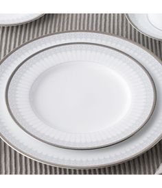 three white plates with silver trim on them