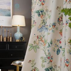 a room with a dresser, lamp and pictures on the wall above it that is decorated in blue and green