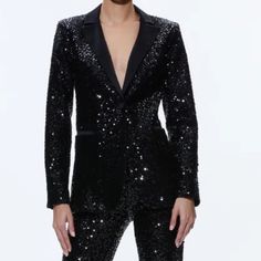 a woman in black sequin suit posing for the camera with her hands on her hips