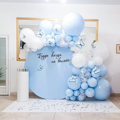 balloons and confetti are arranged on the floor in front of a blue backdrop