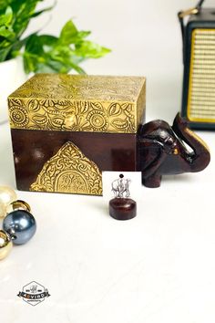 an elephant figurine sitting next to a wooden box and other ornaments on a table