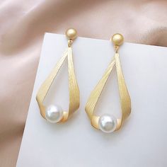 * Buy 2 sets of women’s pearl earrings and receive a free jewelry organizer * Buy more than 2 sets of women’s pearl earrings to receive a $10 discount and a free mirror jewelry organizer Vintage Pearl Earrings Take a look at our beautiful pearl earring design. These pearl drop earrings have been designed by a nature-originated jewelry designer and are made with faux pearls to give you an affordable and vintage style. Made with shell pearls and silver pins, these pearl earrings are easy to care f Pearl Earrings Designs, Statement Earrings Wedding, Simple Pearl, Jewelry Mirror, Shape Geometric, Double Ring, Pearl Types, Pearl Charms, Round Pendant