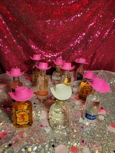 a table topped with lots of bottles filled with different types of liquids and confetti