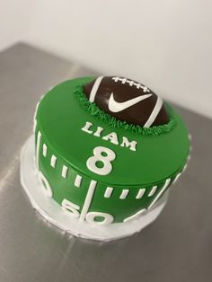 a football themed birthday cake with green frosting and white lettering on the bottom layer