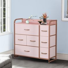 a pink dresser with drawers in a blue room