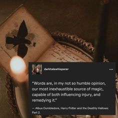 an open book sitting on top of a table next to a candle