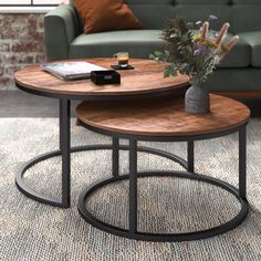 two wooden tables sitting on top of a rug in front of a couch and coffee table