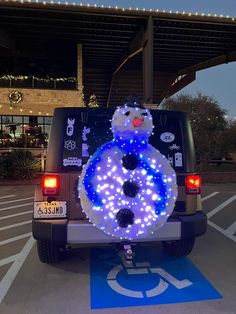 a car is decorated with lights in the shape of a snowman on it's back