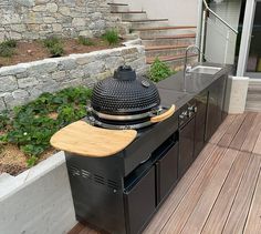 an outdoor bbq grill on a deck with stairs leading to the back door and patio