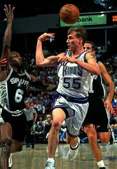 the basketball player is trying to block the ball from being guarded by two other players