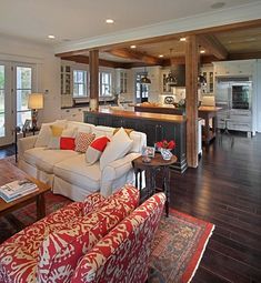 a living room filled with furniture and a kitchen in the backgroung area