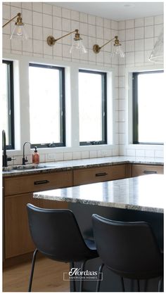 a kitchen with three windows and four chairs