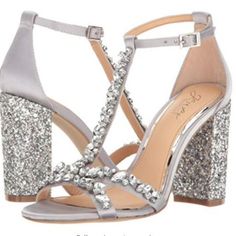 Jewel Badgley Mischka Carver Silver Embellishment Glitter T-Strap Heels Carver Is A Satin, Open Toe Dress Sandals With Glitter-Encrusted Block Heels And Embellished T-Strap By Badgley Mischka's Jewel Line; A Collection Of Sought-After, Unique Shoes To Complement Any Scene-Stealing Ensemble. Womens Sizes: 6, 6.5, 9 Brand New With Original Box Comes With Embellishment And Heel Replacements 3.5 Inches Of Heel Height Glittered Heels Open Toe Dressy Sandals Style Adjustable Ankle Strap With Buckle Cl Shoes Glitter, Jeweled Shoes, Jewel Badgley Mischka, Dressy Sandals, Glitter Pumps, Chunky Heel Pumps, Glitter Sandals, Badgley Mischka Shoes, T Strap Heels