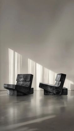 two black and white chairs sitting next to each other in front of a large window