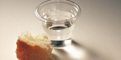 a piece of bread sitting on top of a table next to a glass filled with water