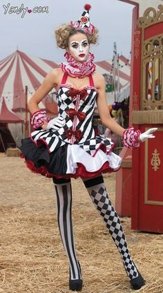 a woman dressed as a clown standing in front of a carnival tent with her hands on her hips