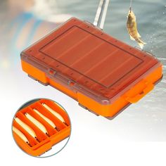 an orange plastic case with four fish hooks attached to the inside of it and on top of water