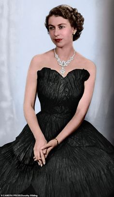 an old photo of a woman in a black dress with a diamond necklace on her neck