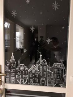 the reflection of a man standing in front of a window with snowflakes on it