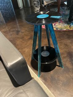 the record player is sitting on top of an end table in front of a couch