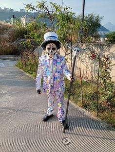 a man in a suit and hat holding a stick