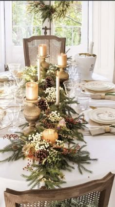 a dining room table decorated with pine cones and candles