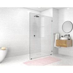 a bathroom with a sink, toilet and shower stall in white tiles on the wall