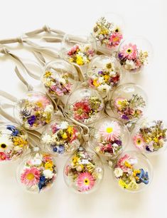 a bunch of glass ornaments with flowers in them