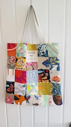 a multicolored tote bag hanging on a white wall